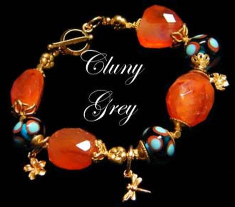 Carnelian bracelet with lamp worked beads, flower and dragonfly charms and gold.