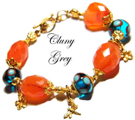 Carnelian bracelet with lamp worked beads, flower and dragonfly charms and gold.