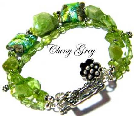 Peridot bracelet of two strands with lamp worked beads, sterling silver and flower charm.