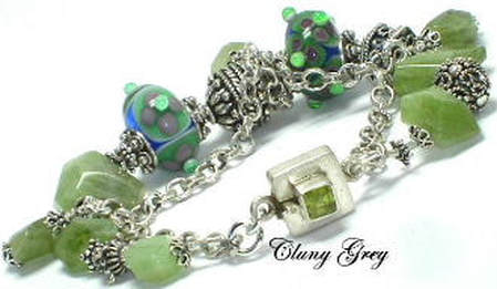 Two strands peridot bracelet with lampworked and sterling silver beads, three peridot nugget and charms.